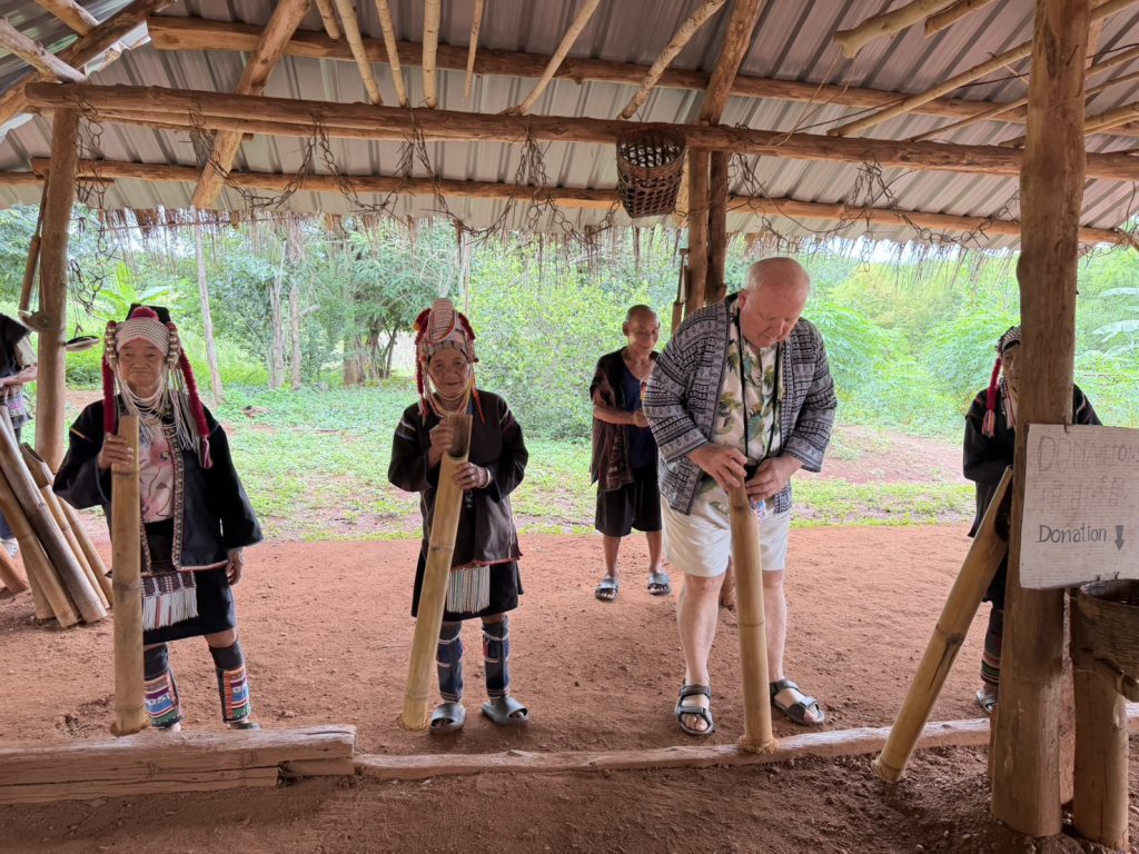 Resident learning to use a traditional bamboo rice-pounding tool in Northern Thailand