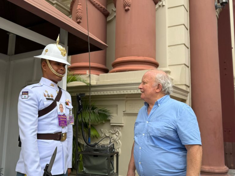 Homerly resident posing beside a Royal Guard at the Grand Palace in Bangkok